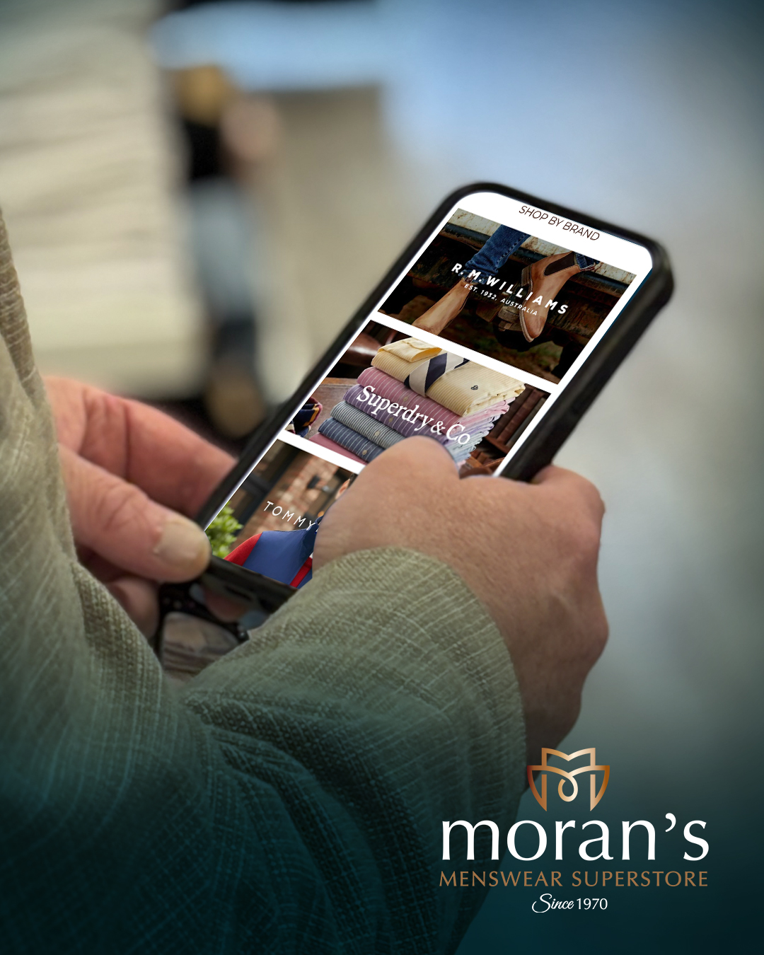 Hands of man using his mobile phone to check products in online shop